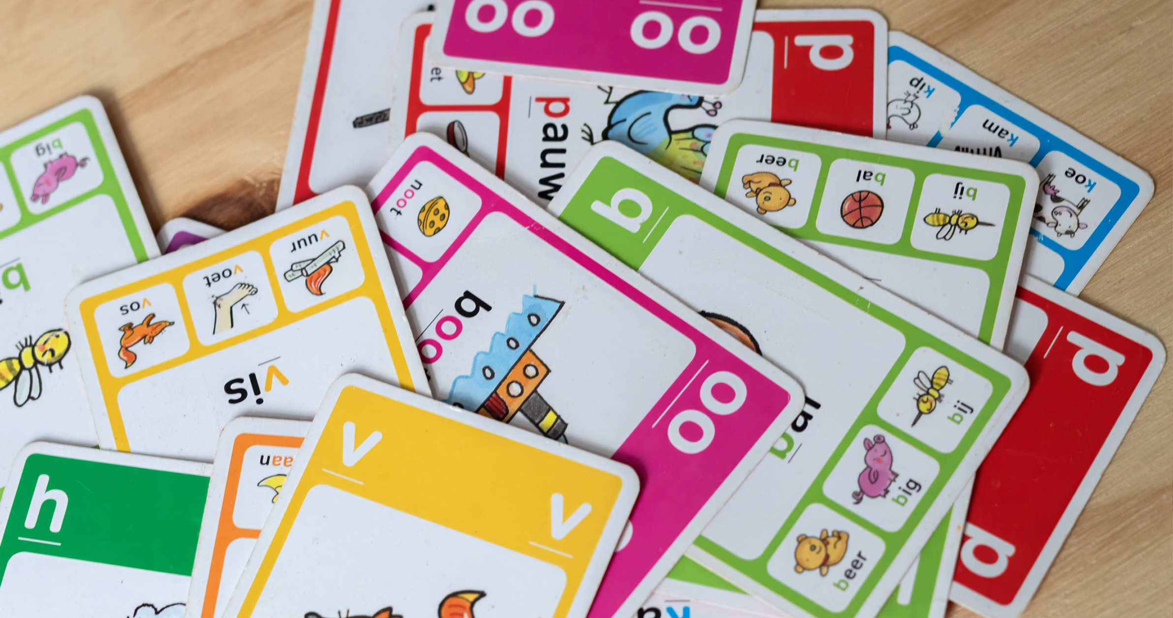Cartes pédagogiques plastifiées colorées, avec illustrations et mots simples (alphabet et vocabulaire) en tas.
